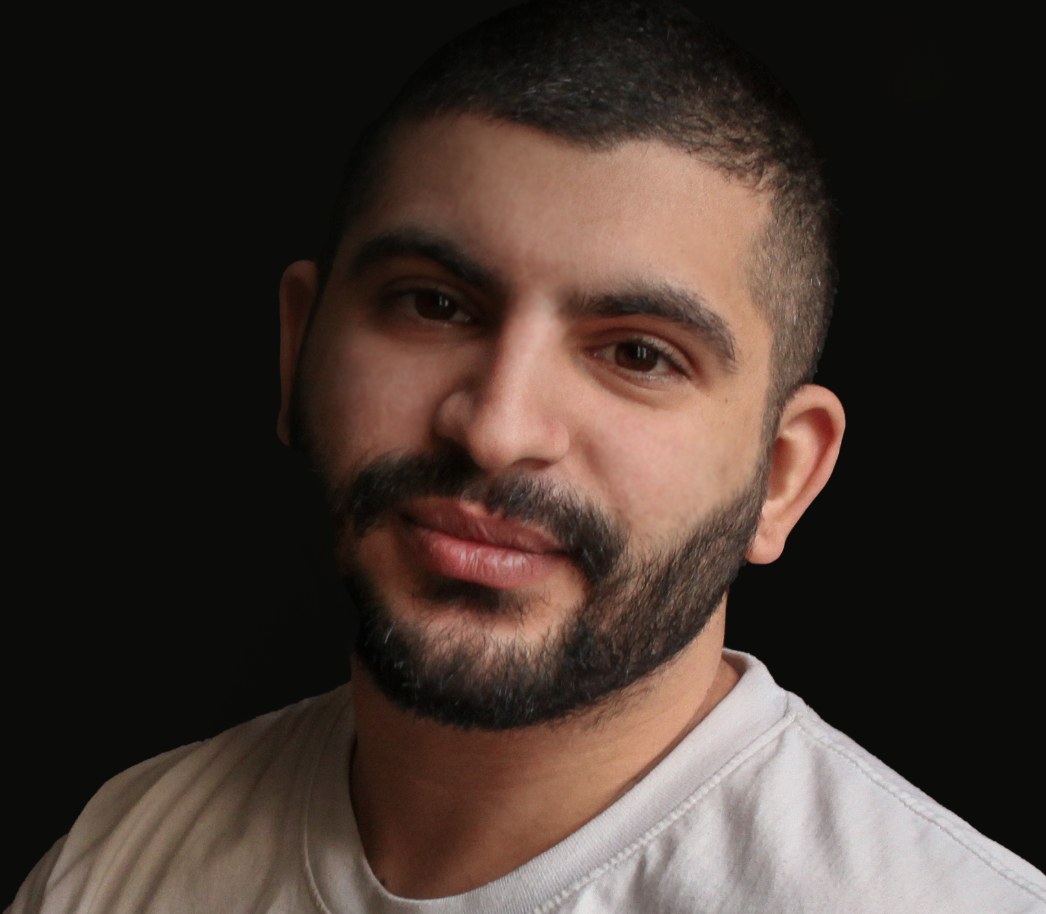 Guy Amar, smiling, against a dark background